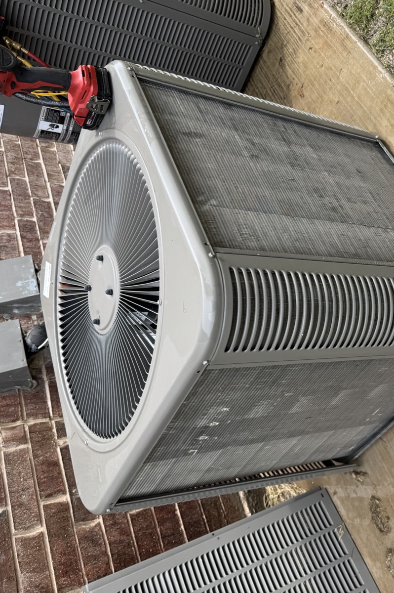 AC tune-up in Celina, TX — condenser coil freshly washed with water still on the fins and pad, meter and cordless tools on site for the electrical checks