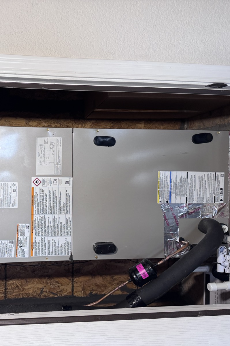 Carrier air handler labelled R-454B, the low-GWP refrigerant used in new systems, with the insulated suction line, condensate trap and 20x20 filter rack