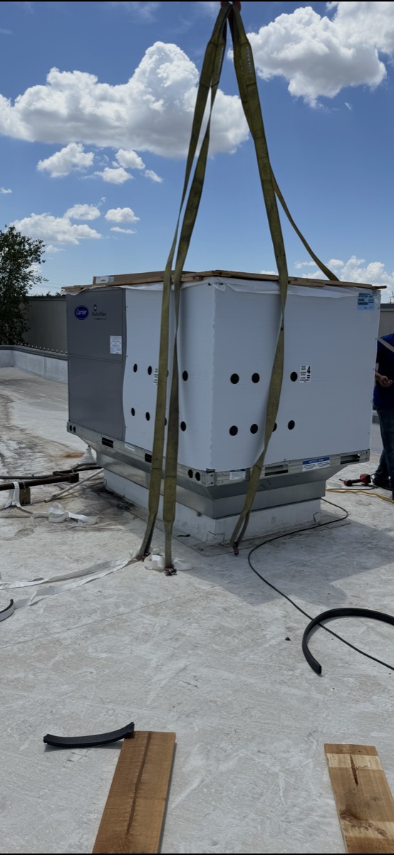 Carrier WeatherMaker commercial rooftop unit being installed on a curb by Panda Heating and Cooling in North Dallas, TX