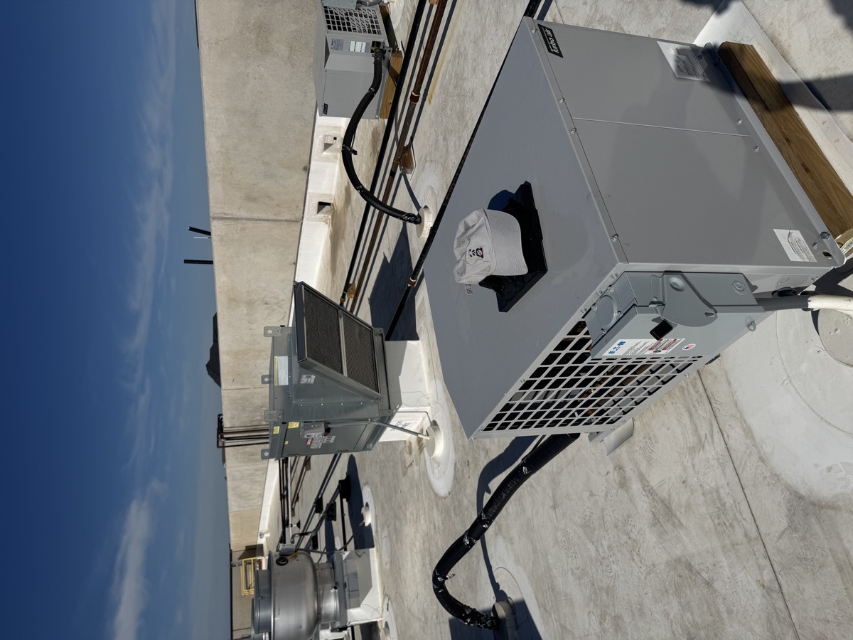 Rooftop condensing units for a commercial refrigeration system, with insulated refrigerant line sets running across the roof, serviced by Panda Heating and Cooling